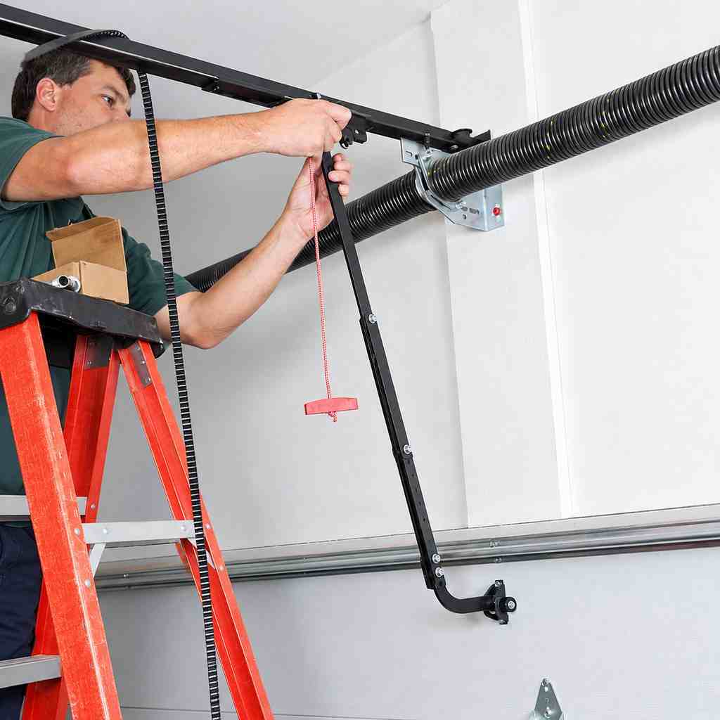 Garage door technician inspecting a torsion spring system in a residential garage